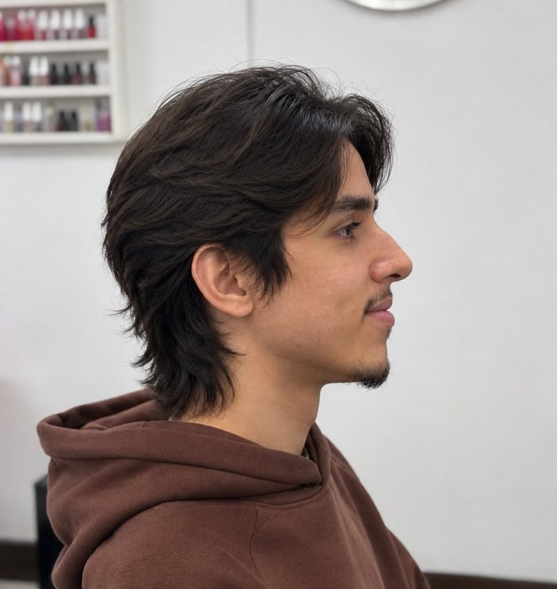 Corte masculino com volume e nuca mais longa, visto de perfil